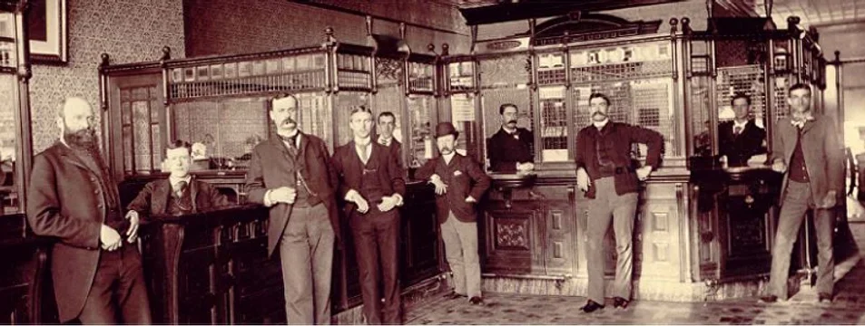 A wide shot of A.V. Hunter and other men standing in his Carbonate National Bank.
